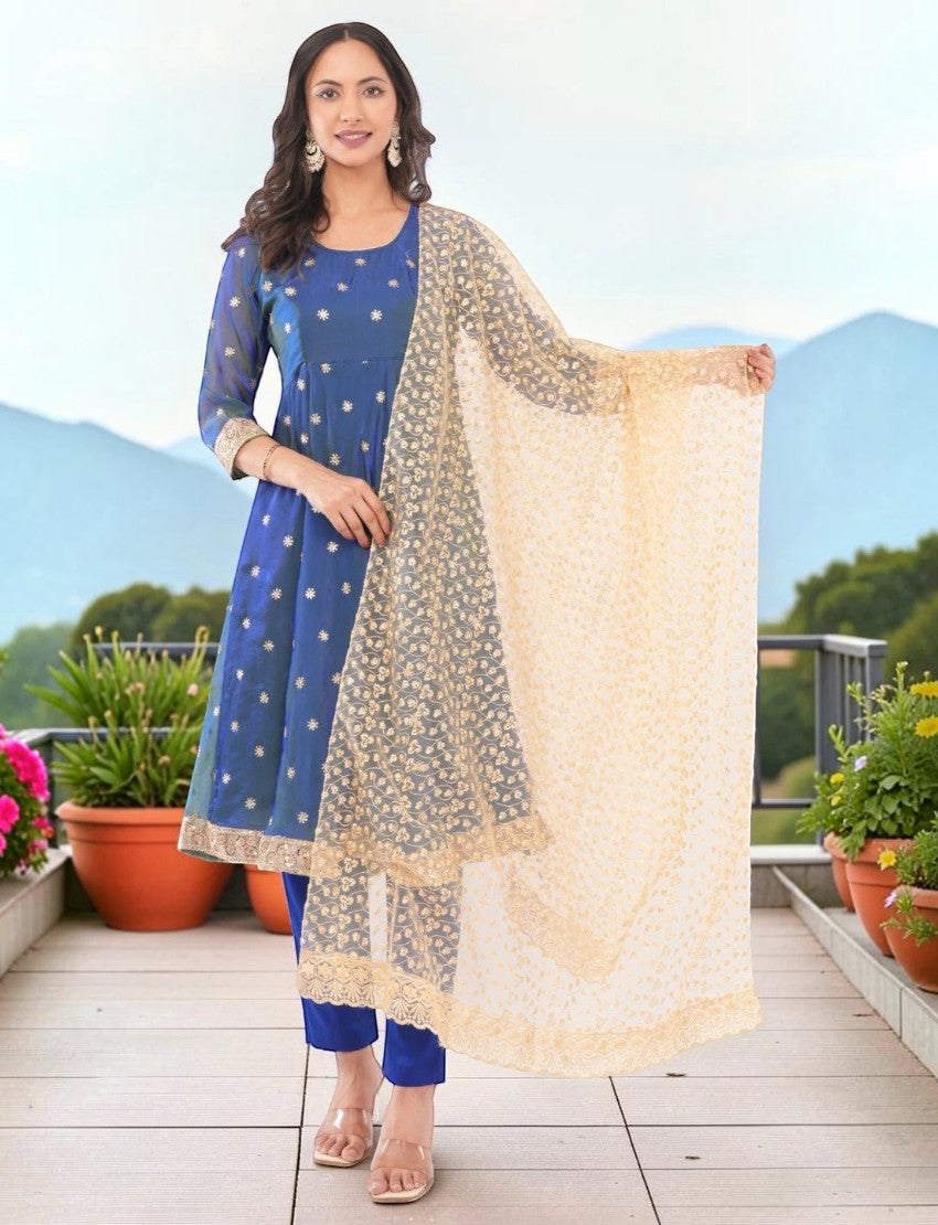 Model wearing an Eelika blue silk blend Anarkali kurta with floral embroidery, trousers, and a sheer beige dupatta.