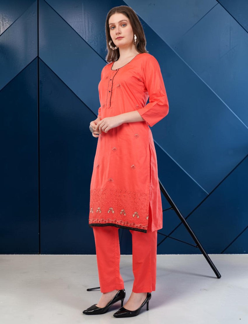 Eelika coral red cotton salwar suit set with 3/4 sleeves, black lace border, and embroidery, worn by a model.