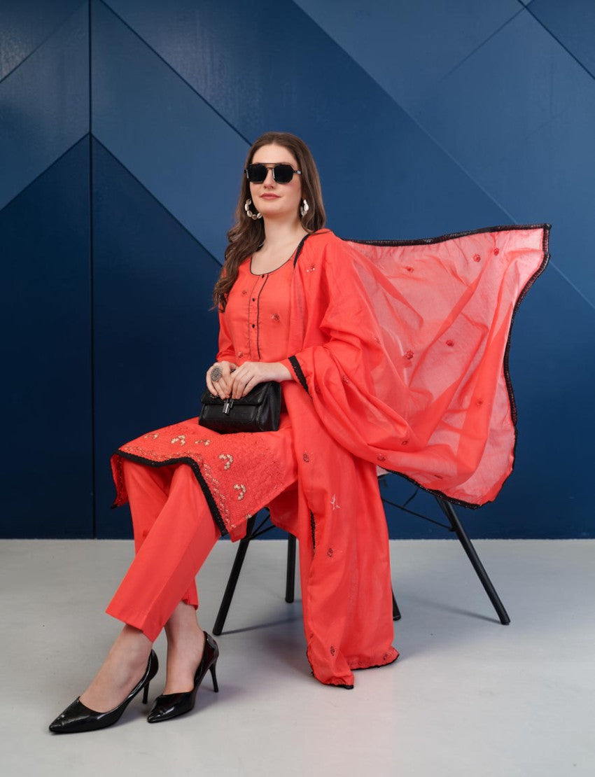 Eelika coral red cotton salwar suit set with embroidered details, black lace border, and matching dupatta.