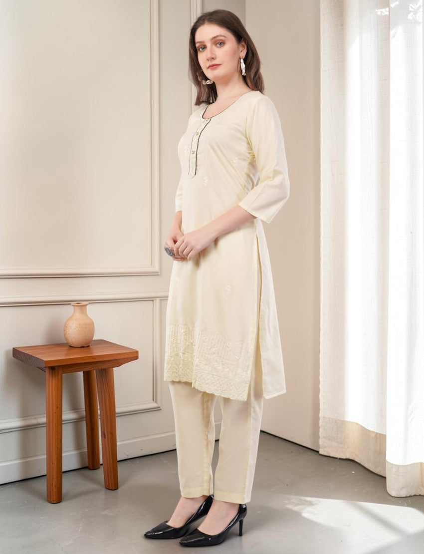 Eelika cream cotton salwar suit set featuring a knee-length printed kurta with 3/4 sleeves and matching trousers.