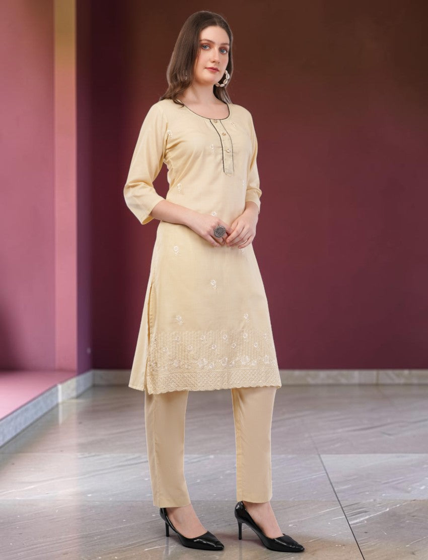 Eelika cream cotton salwar suit set featuring a knee-length kurta with embroidery, 3/4 sleeves, and matching trousers.