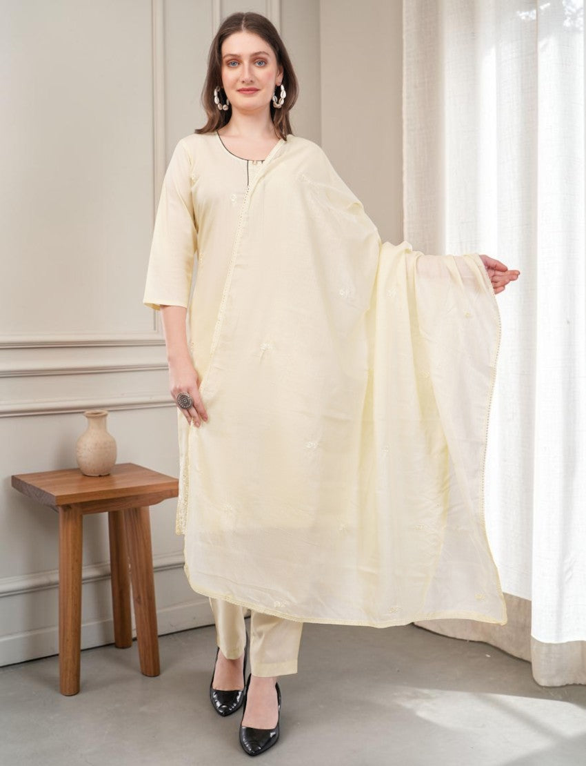 Model wearing an Eelika cream cotton salwar suit set with 3/4 sleeves, embroidered details, and matching dupatta.