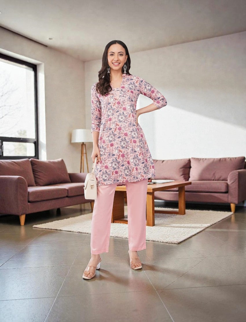 Model wearing an Eelika floral print cotton blend kurta with V-neck, 3/4 sleeves, and solid pink palazzo trousers.
