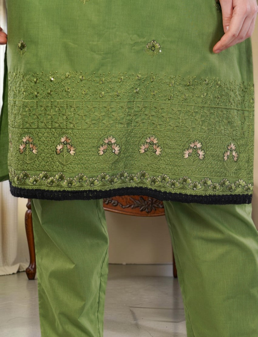 Eelika green cotton salwar suit featuring intricate floral embroidery and a contrasting black lace hem trim