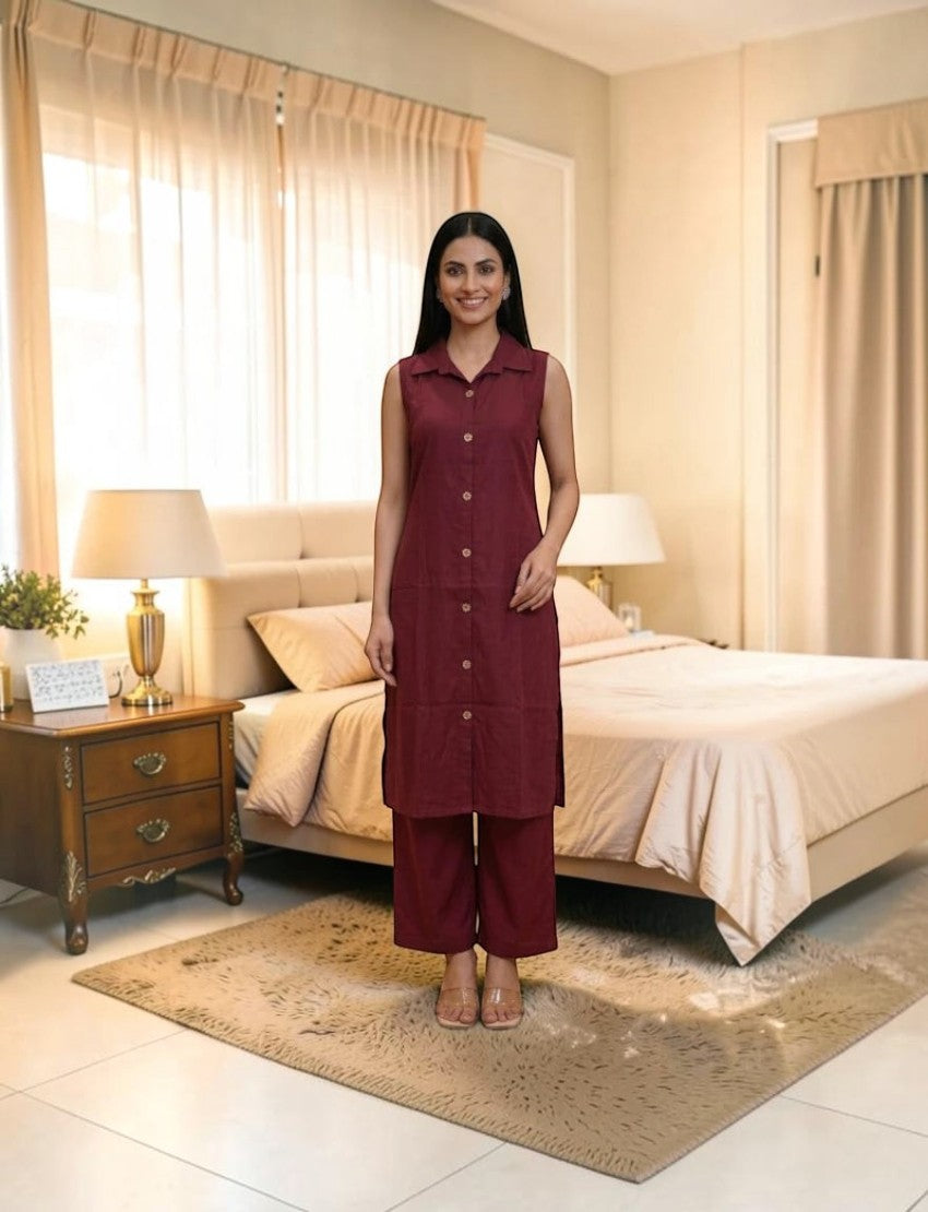 Model wearing an Eelika maroon sleeveless cotton salwar suit with a shirt collar and button-down kurta in a bedroom.