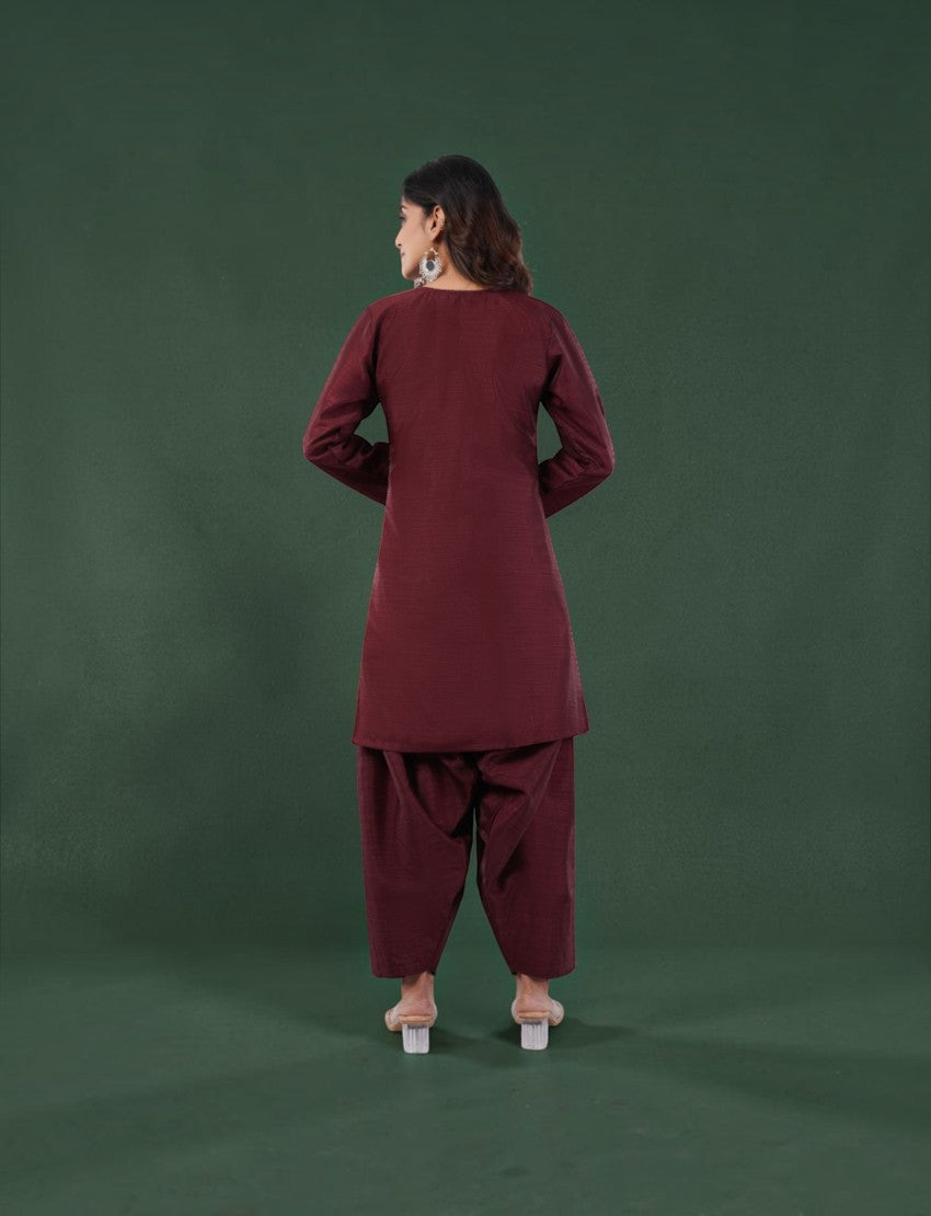 Back view of a woman wearing a maroon Eelika silk blend farshi suit set with 3/4th sleeves and V-neck kurta.
