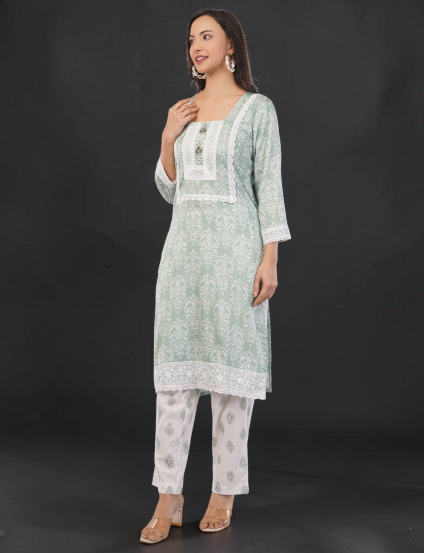 Eelika mint green cotton salwar kameez set with floral print, square neck, 3/4 sleeves, and white lace detailing.
