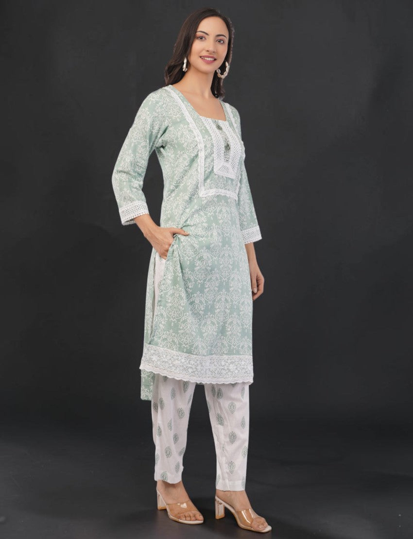 Eelika mint green cotton salwar kameez with floral print, white lace trim, square neck, and 3/4th sleeves on a model