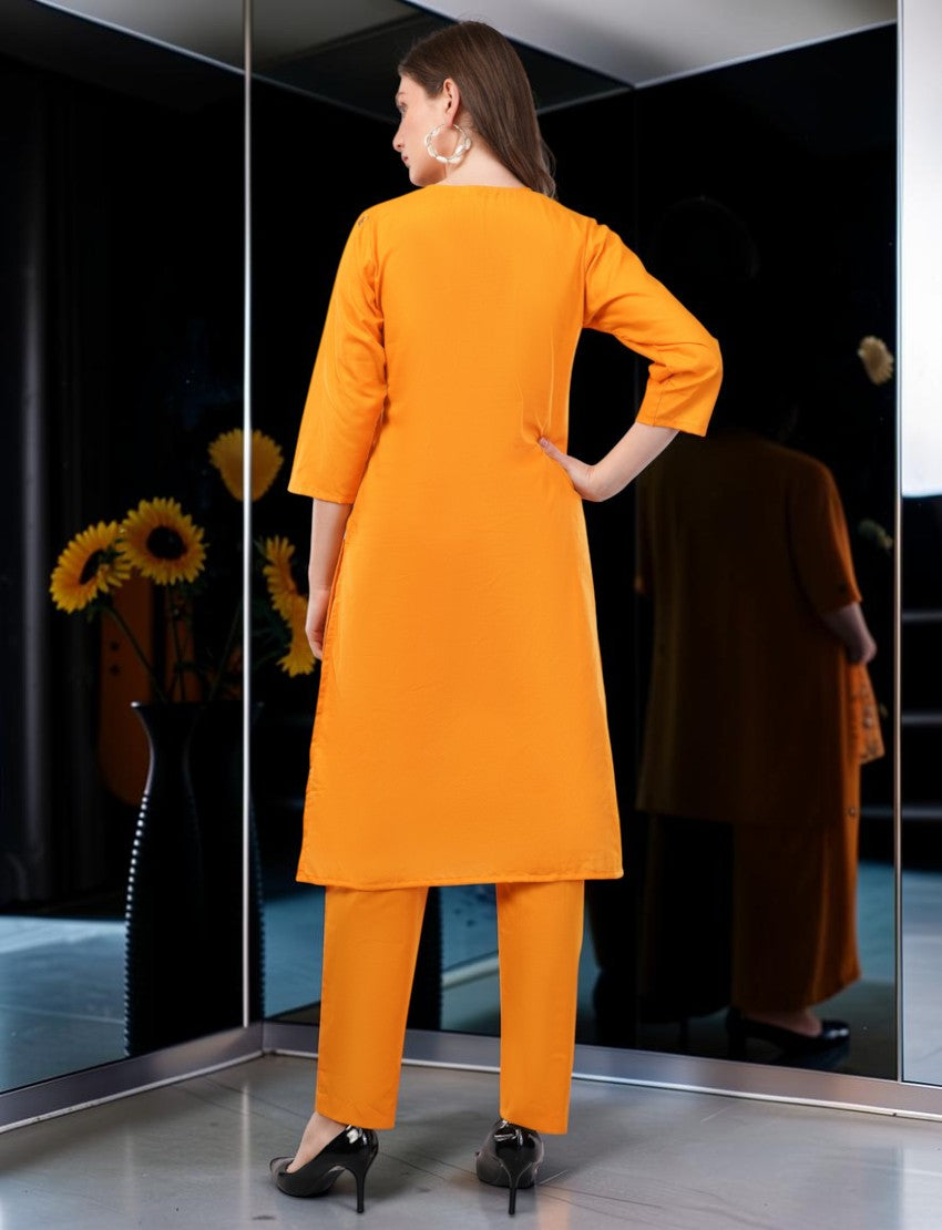 Eelika orange cotton salwar suit with 3/4 sleeves and trousers, worn by a model in a studio setting