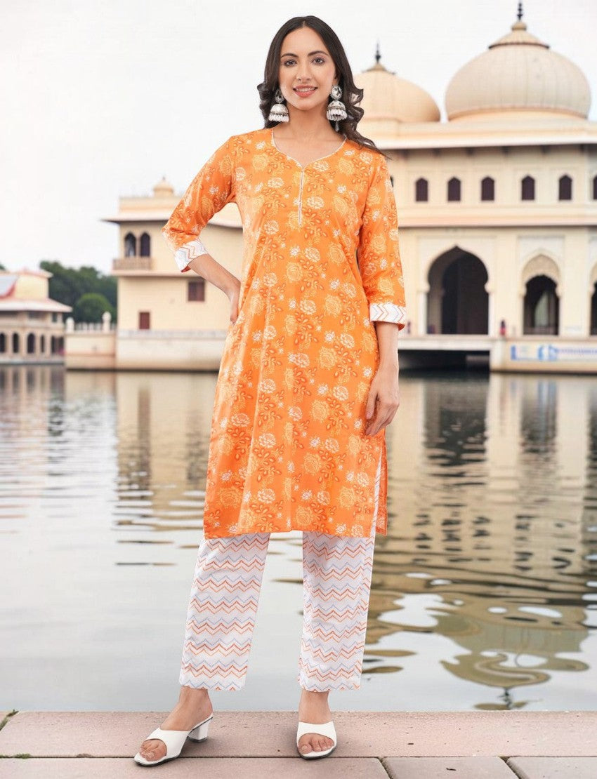 Eelika orange cotton salwar suit set with floral paisley print, V-neck, 3/4 sleeves, and chevron printed trousers.