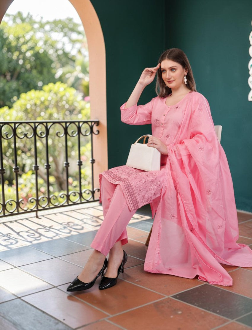 Eelika pink cotton salwar suit set with embroidered kurta, trousers, and dupatta worn by a woman on a balcony