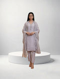 Model wearing an Eelika light purple cotton salwar suit set with V-neck, 3/4 sleeves, trousers, and matching dupatta.