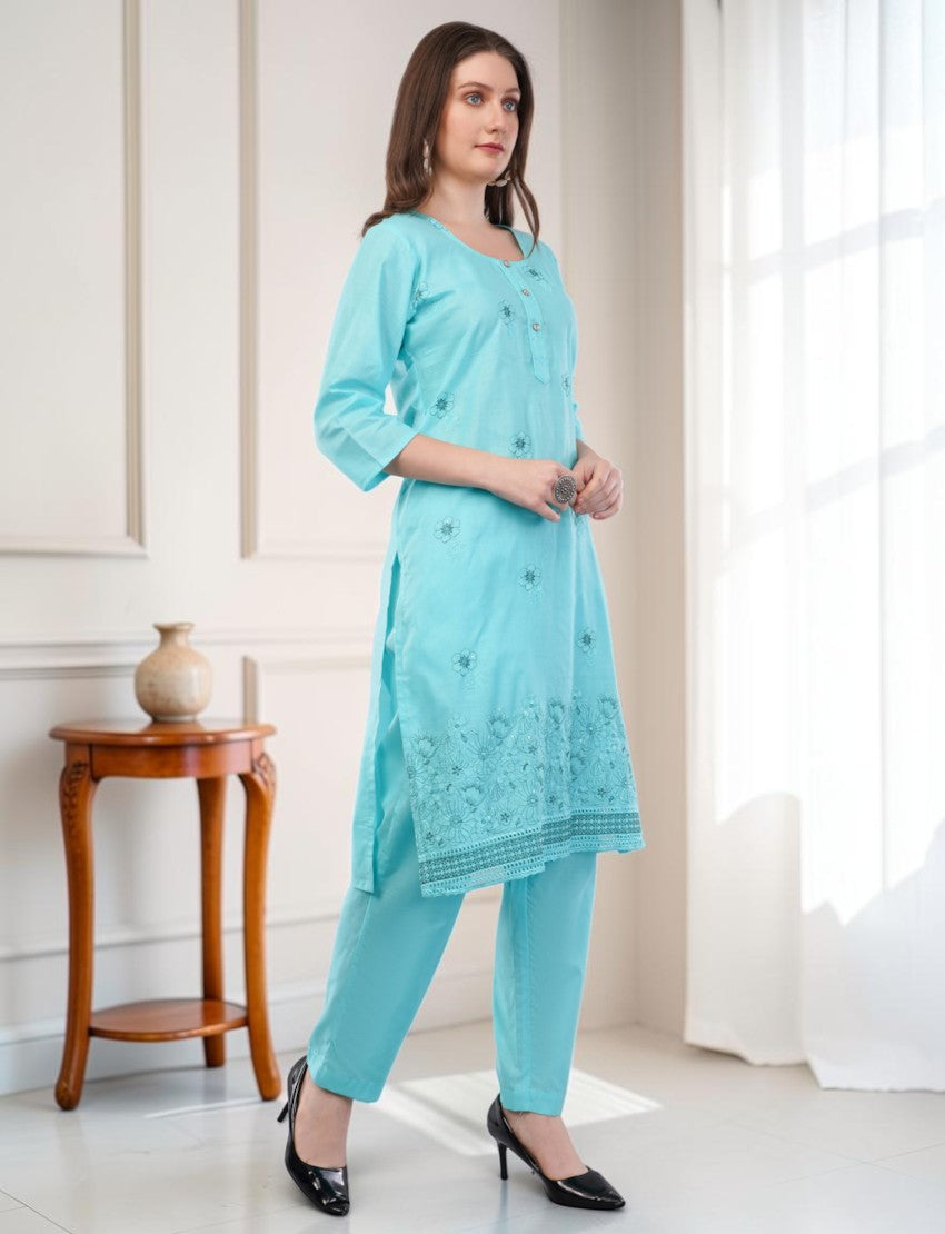 Model wearing an Eelika turquoise cotton salwar suit set with 3/4th sleeves, embroidery, and matching trousers.