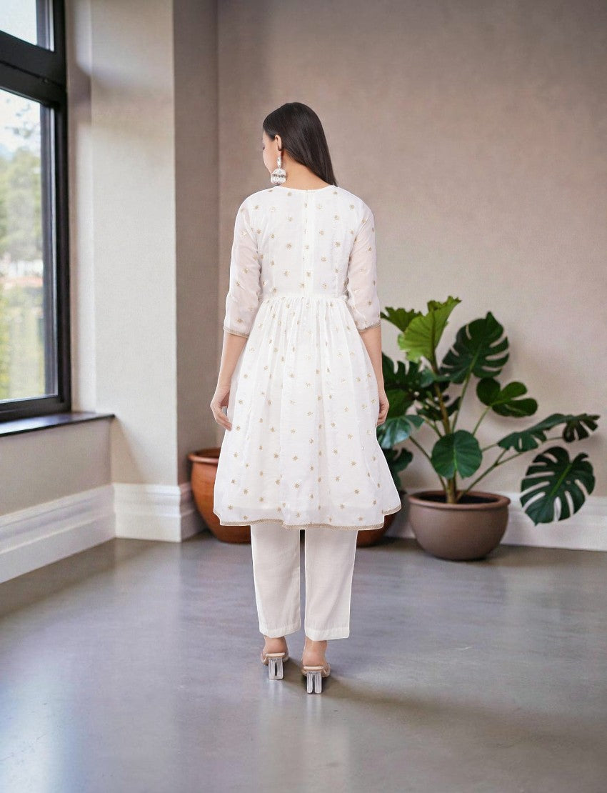 Eelika white chiffon salwar suit set with gold embroidery, calf-length kurta, 3/4 sleeves, and matching trousers.