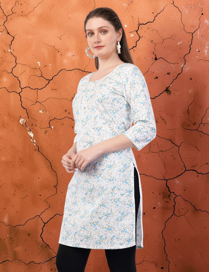 Eelika women's white cotton kurti featuring a blue floral print, round neck, and 3/4 sleeves, worn by a model.