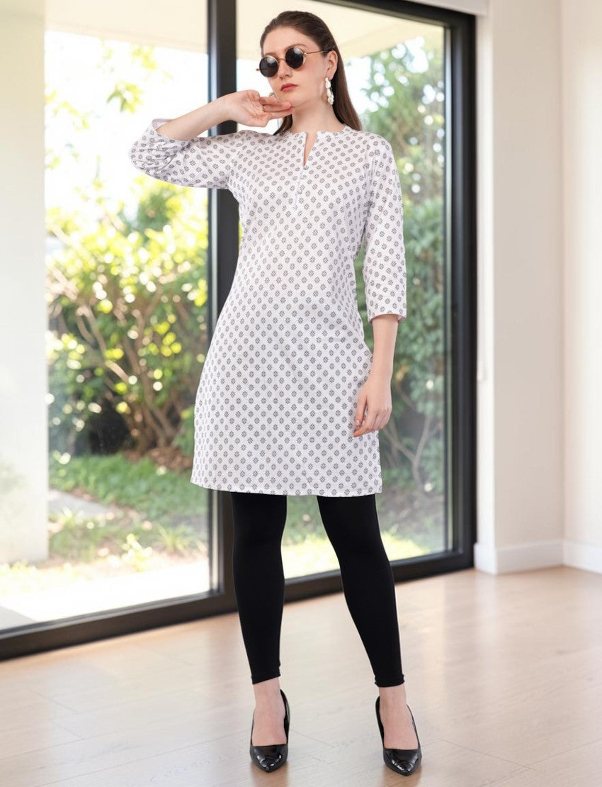Eelika white cotton kurti featuring a geometric print, mandarin collar, and 3/4 sleeves worn with black leggings