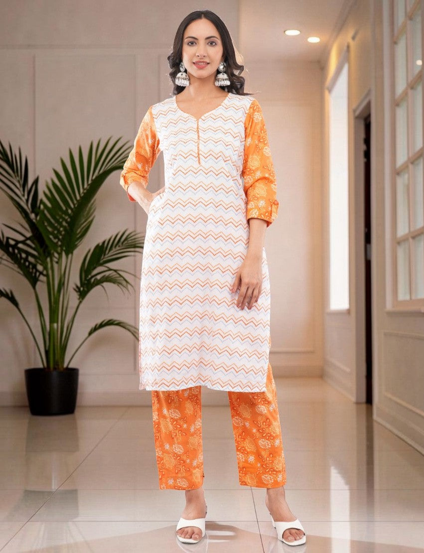 Eelika white and orange cotton salwar suit set with geometric print, V-neck, 3/4 sleeves, and matching trousers.