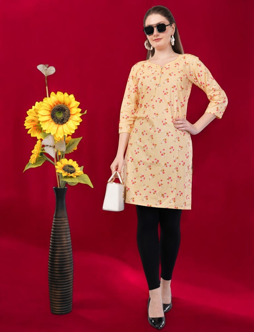 Eelika women's yellow cotton kurti with floral print, round neck, and 3/4 sleeves, styled with black leggings.